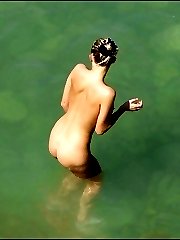 Spying on a nude gal taking a tan and enjoying the sea