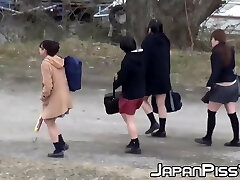 Four Japanese college girls fool around outside before peeing