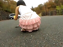 Chinese teen leans over and shows horny upskirt in the street