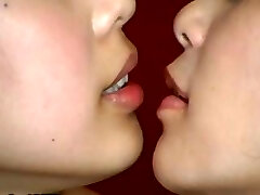 Two Asian femmes are doing some weird kissing with a mouth speculum
