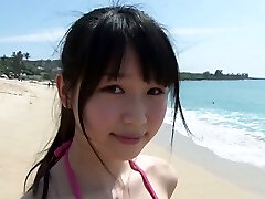 Slim Asian doll Tsukasa Arai ambles on a sandy beach under the sun