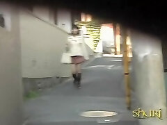 सार्वजनिक के साथ जापानी लड़की में एक संकीर्ण सड़क