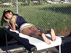 Cheerleader without panties sunbathing on the massage table