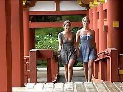 couple de lesbiennes s'embrassant et clignotant dans un temple japonais