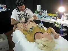 Light-haired bimbo moans with pain as her pubis was being inked