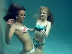Two girls breath holding and posing underwater