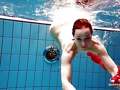 Cute babe in red sexy open dress swimming