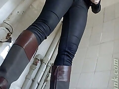 Pale skin blonde girl in boots pisses in the toilet