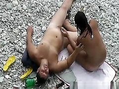 Black hair nudist and her man at beach