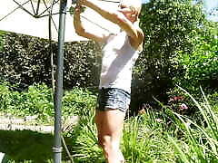 Alexa Cosmic trans girl wetting & wetlook in the garden in white t-shirt and denim shorts under water from a hose...
