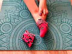 Gloria Gimson in pink socks caresses her shoulder massage on a yoga mat