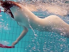 Pelirroja Libuse de natación en una piscina en el fuego con un vestido rojo