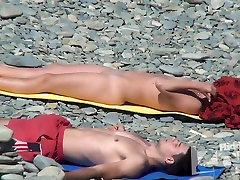 Biorąc urocze dziewczyny odpoczywają na plaży dla nudystów