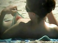 The downblouse girl becomes an object of a hidden spy cam on the beach