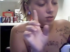 Ponytailed blonde girl writes all kinds of words on her naked body in the kitchen