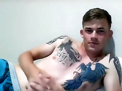 Handsome boy is playing in a small room and shooting himself on computer webcam