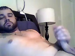 Sexy tattooed guy shooting on bed