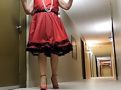 Sissy monster clit suck in Red Teffeta dress in hotel hallway