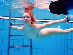 Redhead babe swimming naked in the pool