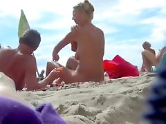 美丽的赤裸裸的妇女窥探在海滩上的裸体