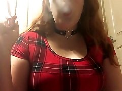 sexy redhead goth teen rauchen in roten karierten engen kleid und leder halsband