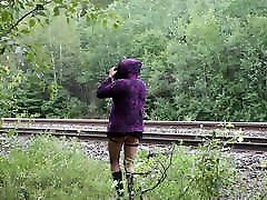 Shy transgender flashing by train tracks