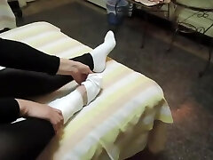 Woman takes off white sock to reveal her bandaged ankle