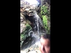 naked in public, nudism. showering in a beach waterfall.