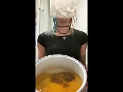 Transgirl pouring huge bucket of salint sex over head in satin