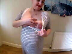 femme enceinte fait un strip-tease en robe de maternité