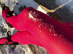 Crossdresser posing in pink pantyhose on snowy stairway