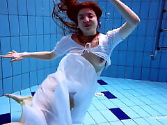 marketa rousse en robe blanche dans la piscine