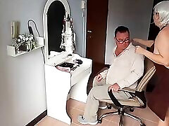 Nudist barbershop. sexy big white girls lady hairdresser in an apron makes client to strip. The client is surprised. S1