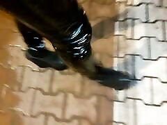 a crossdresser in high wedge platform shoes and mom my babe leggings is walking the streets at night