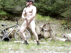 Muscle stud gets naked on a bike ride, flexes muscles lifts huge logs and cums old vid