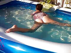 nena elegante y flexible, nadando bajo el agua en la piscina al aire libre. suite de baño