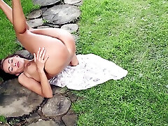 Nude brunette Michaela Isizzu poses outdoors at heel dildo milf photo shoot
