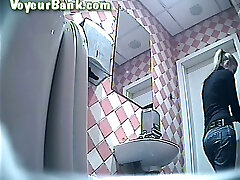 dulce mujer rubia alta en el baño público para damas filmada en cámara