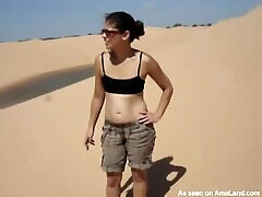 शरारती श्यामला लड़की रेगिस्तान में उसके स्तन चमकती