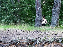 गोल-मटोल सफेद श्यामला लड़की जंगल में स्क्वाट और पेशाब पहाड़ी पर