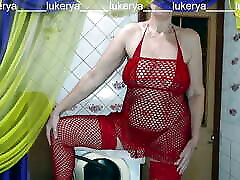 Hot housewife Lukerya in her favorite red fishnet outfit shows off her sexy body while flirting with fans in the kitchen