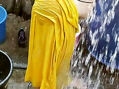 印度房子的妻子在外面洗澡