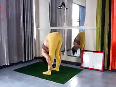 Regina Noir. Yoga in yellow tights doing yoga in the gym. A girl without panties is doing yoga. An athlete trains in a p