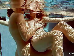 In the indoor pool, two stunning girls swim