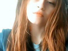 Redhead Asian woman with tattoos blows smoke