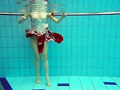 Sizzling redhead model Marketa swimming nude in a pool