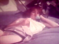 винтажная рыжеволосая красотка с огромными сиськами и черными чулками занимается сольным сексом в своей постели