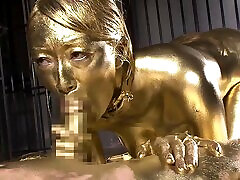 Sex slave covered in golden paint gets frisky with a cock